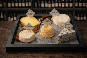 Plateau de fromages français avec Raclette, Brie de Meaux, Bleu d'Auvergne et chèvre pour une dégustation gourmande.