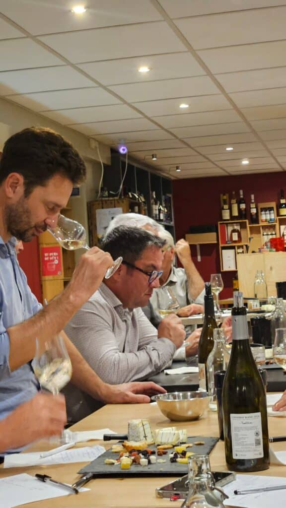 Atelier de Dégustation de Vin Blanc Cheverny et Fromages Séance de dégustation de vin blanc Cheverny avec fromages. Un homme analyse les arômes d'un verre avec concentration.