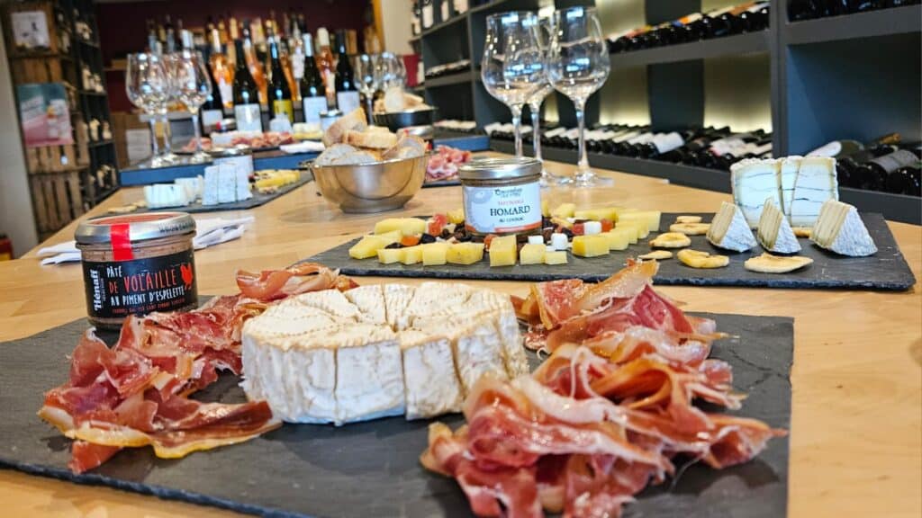 Fromage et charcuterie : dégustation gourmande en cave Plateau de fromage et charcuterie avec pâté de volaille Hénaff et homard au cognac dans une cave à vin.