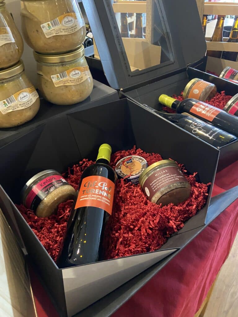Coffret Cadeau Gastronomique : Vin Rouge et Terrines Coffret gourmand avec vin rouge Gif-Paf Turenne, rillettes Kerloïck et terrine Millas sur papier frisé rouge.